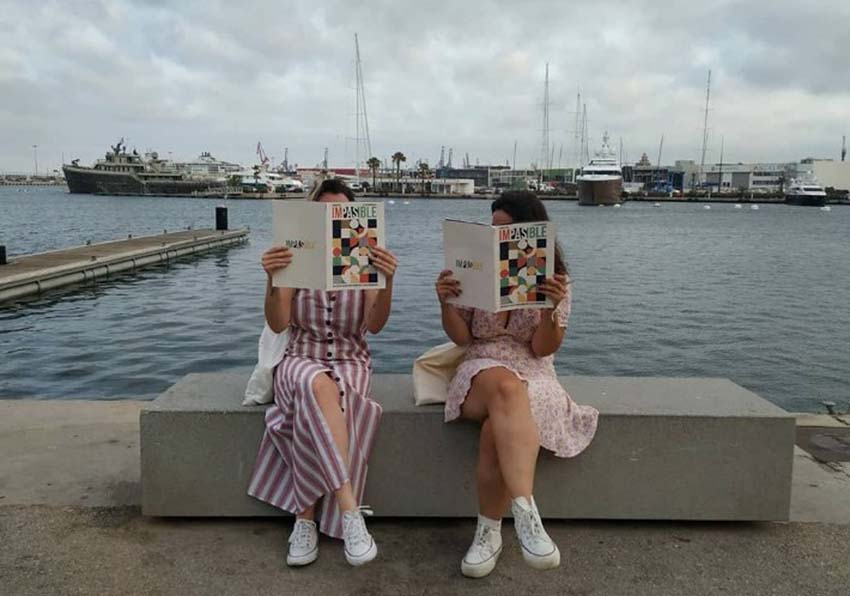 Dos mujeres sentadas leyendo una revista